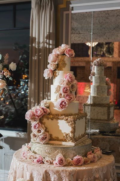 Elegant tiered wedding cake with roses and gold leaf