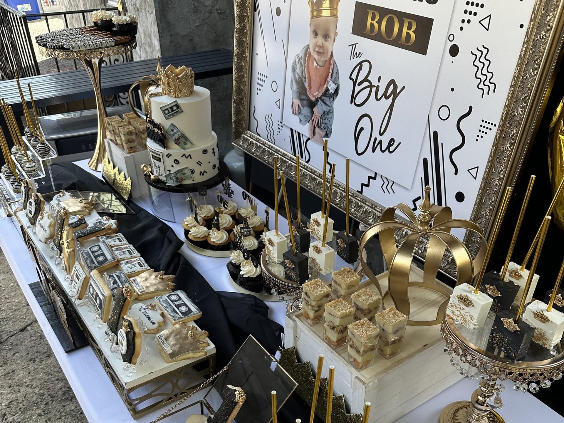 Black and gold Notorious BOB first birthday dessert table